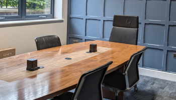 A meeting room with a table and chairs